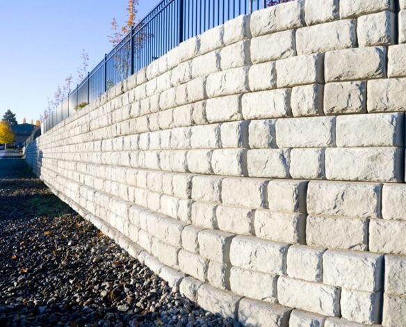 Long retaining wall with a fence on top